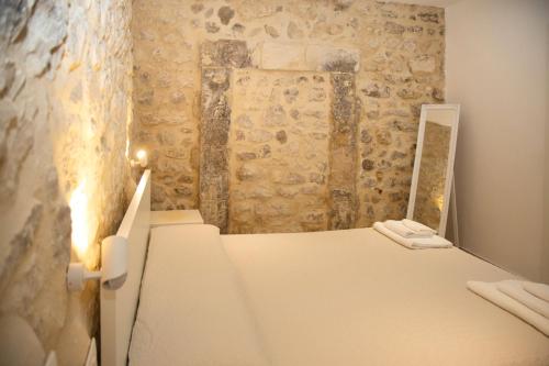 een slaapkamer met een wit bed en een spiegel bij Casa di Gio in Scicli