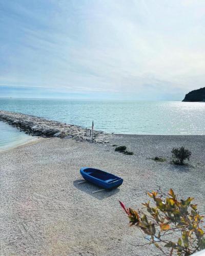 a blue boat sitting on a beach next to the ocean at Casa Junno in Mattinata