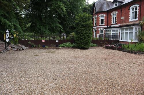 a gravel driveway in front of a house with a fence at The Parks in Torquay