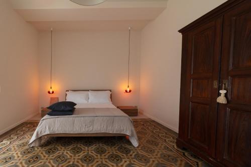 a bedroom with a bed with two lamps and a door at Hotel Ristorante San Giuseppe in Cernobbio
