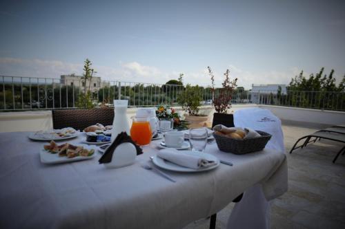a white table with food and drinks on a balcony at Casale del Murgese Country Resort in Savelletri di Fasano