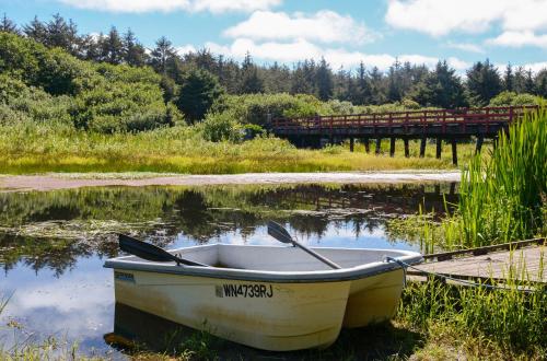 a boat sitting in the water next to a dock at Surfcrest Resort in Copalis Beach