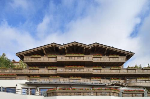 a building with balconies and flower boxes on it at Guarda Golf Hotel & Residences in Crans-Montana