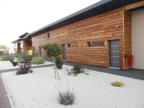 Una casa con fachada de madera con plantas. en Bio Motel, en Semoutiers