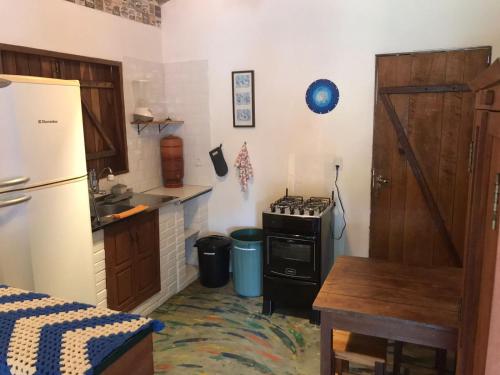 a kitchen with a refrigerator and a stove at Pousada Morro da Baleia in Alto Paraíso de Goiás
