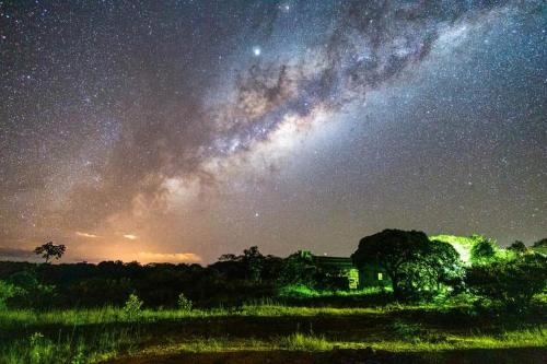 a starry night with a house in a field at Pousada Morro da Baleia in Alto Paraíso de Goiás