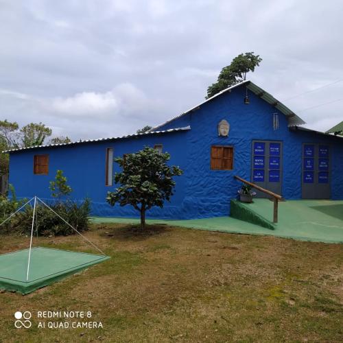a blue building with a golf course in front of it at Pousada Morro da Baleia in Alto Paraíso de Goiás