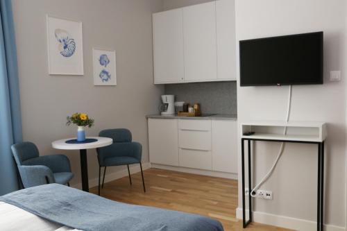 Pokój z łóżkiem, telewizorem i stołem w obiekcie Apartament Żeromskiego 17 - Insel Apartamenty w Świnoujściu