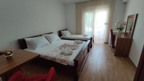 a bedroom with a bed and a table and a window at Robi Apartments in Ulcinj