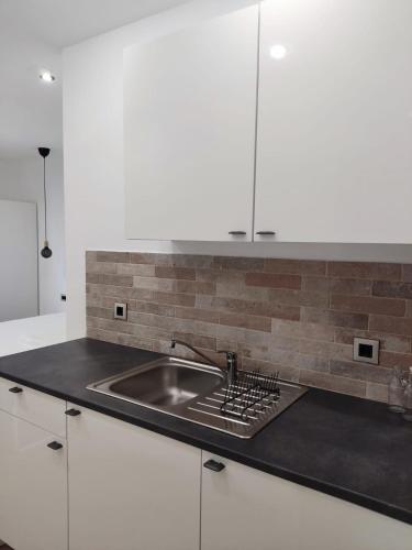 a kitchen counter with a sink and white cabinets at Mina Lux Jelsa in Jelsa