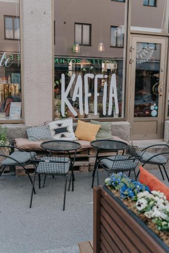 a cafe with tables and chairs in front of a store at West Coast Hideaway in Pietarsaari