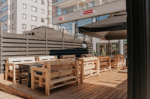 a patio with wooden tables and chairs and an umbrella at West Coast Hideaway in Pietarsaari