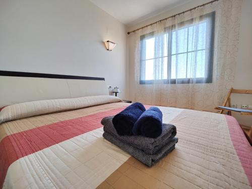 een slaapkamer met een bed met twee blauwe kussens erop bij MIRADOR vacation home in Cala de Finestrat