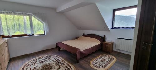 a small bedroom with a bed and a window at Karacsony Guest House in Lunca de Sus