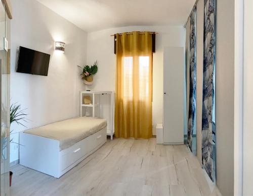 a bedroom with a bed and a yellow curtain at Noemi Holiday House in Agnone Bagni