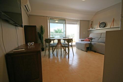 sala de estar con mesa y sofá en Dúplex playa Torrenostra, en Torreblanca