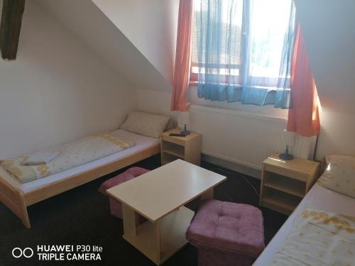 um pequeno quarto com duas camas e uma mesa em Penzion U Hladů em Úlice