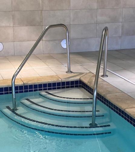 a swimming pool with two metal faucets at Holiday Inn Express & Suites Warrensburg North by IHG in Warrensburg