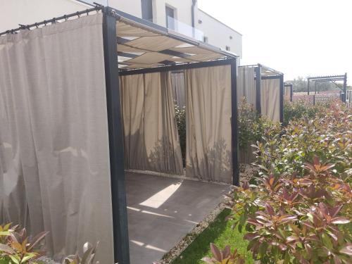 a privacy fence with curtains in a garden at PINNA RESIDENCE - VANGA in Pula