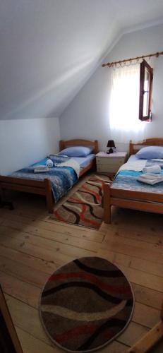 a bedroom with two beds and a rug on the floor at Vikendica Borje in Žabljak