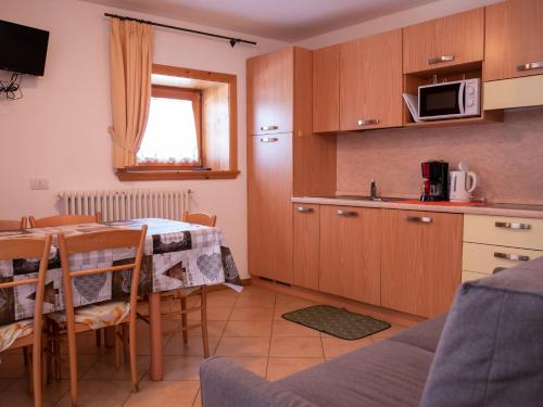 a kitchen and dining room with a table and a microwave at Bait Nof - Trepalle in Livigno