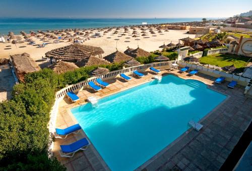 uma vista aérea de uma piscina de resort com guarda-sóis e da praia em Hotel Royal Beach em Sousse
