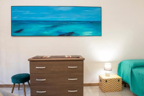 a bedroom with a dresser and a painting on the wall at B.I.C. (bnb in centro) in Sassari