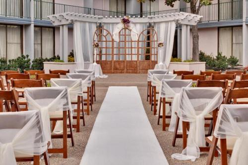 an aisle with white tables and chairs in a building at Holiday Inn Dublin - Pleasanton by IHG in Dublin