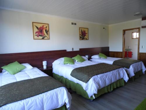 a hotel room with two beds with green pillows at Complejo Pehuen Lago Lanalhue in Cañete