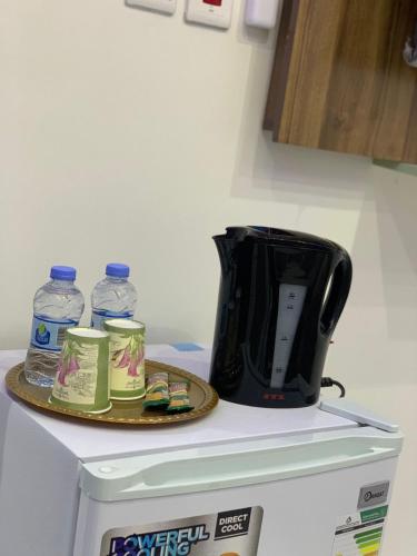 a black toaster sitting on top of a refrigerator at أجنحة عبدالعزيز للوحدات السكنية in Sulţānah
