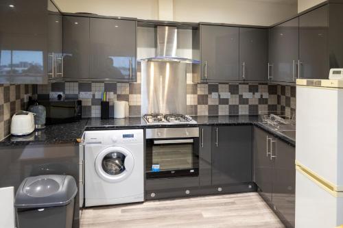 a kitchen with a washing machine and a washer at Entire New Flat With View to River Yare, H7 in Great Yarmouth