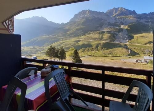 a balcony with a table and chairs and a mountain view at La Mongie, Studio pieds des pistes, parking intérieur privé in La Mongie