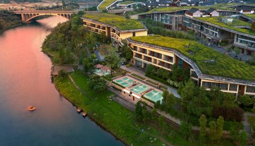 an island with a green roof on a river at Holiday Inn Express Emei Mountain by IHG in Emeishan