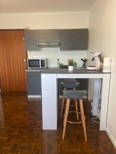 - une petite cuisine avec un comptoir et un tabouret dans l'établissement Studio Rue De Dijon, à La Fillotte