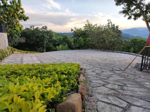 a stone patio with green plants on the side at Mountain View Anapoima in Anapoima