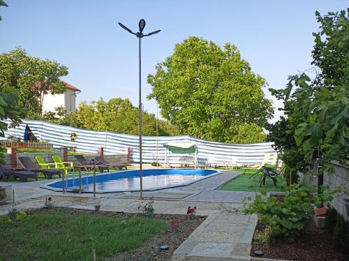 a swimming pool in a yard with a fence at Guest House 51 in Kranevo