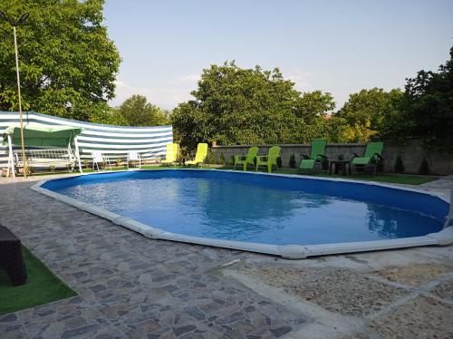 a swimming pool with chairs and a table at Guest House 51 in Kranevo
