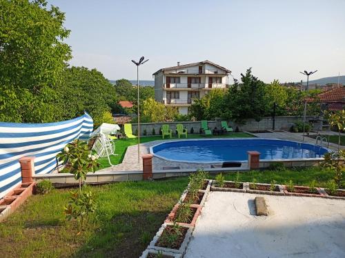a swimming pool in a yard with a building in the background at Guest House 51 in Kranevo