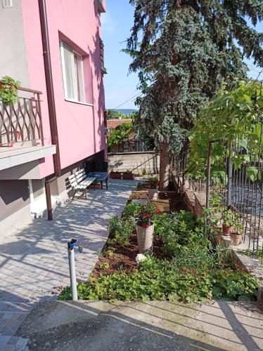 a pink house with a garden in front of it at Guest House 51 in Kranevo
