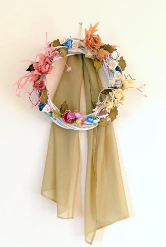 a wreath of flowers is hanging on a wall at Odysseion Apartments in Vathi, Ithaka