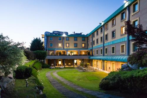 a large building with a lawn in front of it at Crowne Plaza Milan - Malpensa Airport by IHG in Case Nuove