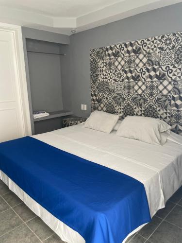 una camera con un letto blu e bianco con un muro di Hotel Rias a Veracruz