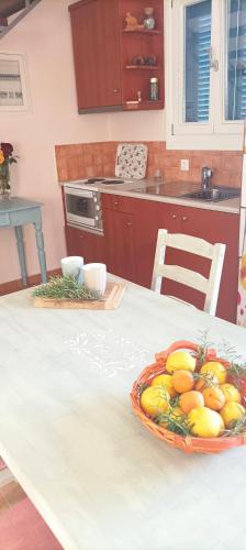 a kitchen with a table with a bowl of fruit on it at Odysseion Apartments in Vathi, Ithaka