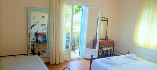 a bedroom with a bed and a mirror and a door at Odysseion Apartments in Vathi, Ithaka