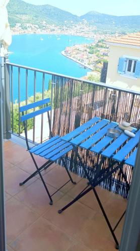 a blue bench sitting on a balcony overlooking the water at Odysseion Apartments in Vathi, Ithaka