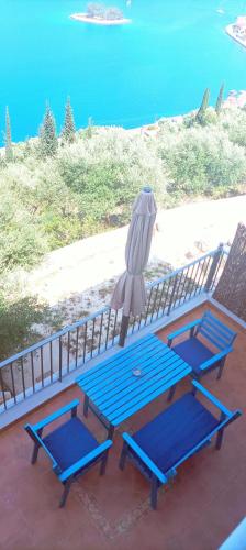 a blue picnic table with an umbrella on top of it at Odysseion Apartments in Vathi, Ithaka