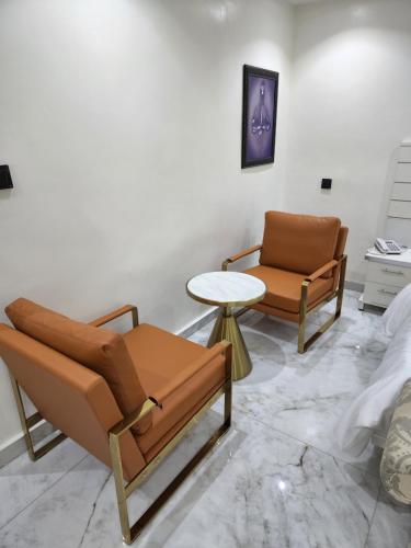 a living room with two chairs and a table at LUXOL HOMES&SUITES in Ikeja