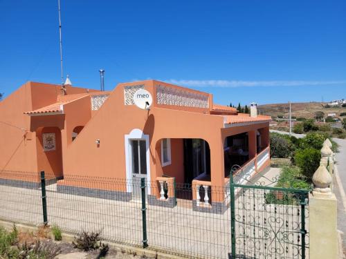 ein großes orangenes Haus mit einem Zaun in der Unterkunft Quinta dos Moledros in Figueira