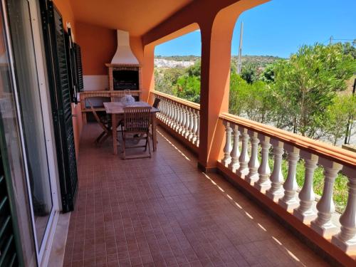 a balcony of a house with a table and chairs at Quinta dos Moledros in Figueira