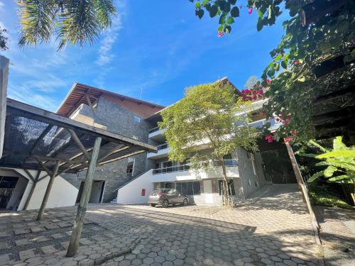 un bâtiment avec une voiture garée devant lui dans l'établissement Refúgio da Lagoinha - Centro de Bombinhas, à Bombinhas